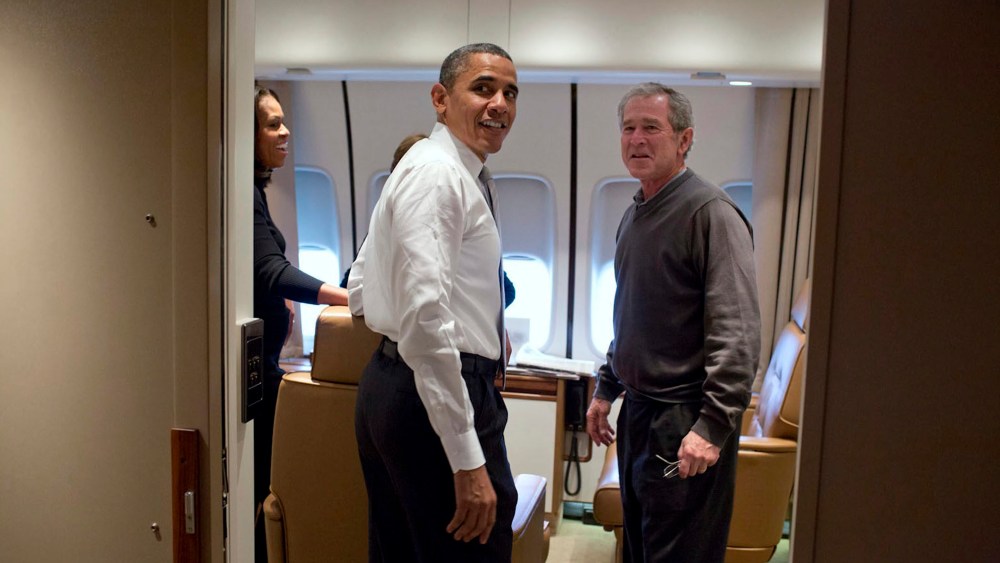Barack Obama jokes with George W. Bush shortly after boarding Air Force One en route to Nelson Mandela's memorial service, Dec. 9, 2013.