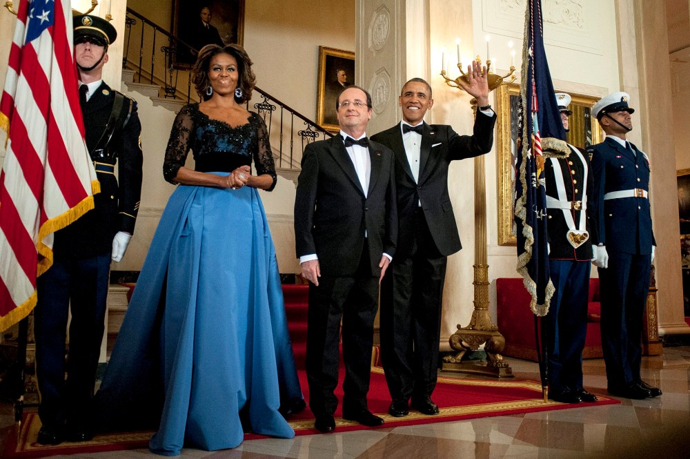 US President Barack Obama and First Lady Michelle Obama pose for a photo with President Francois Hollande of France on the Grand Staircase in the White House in Washington on Feb. 11, 2014.