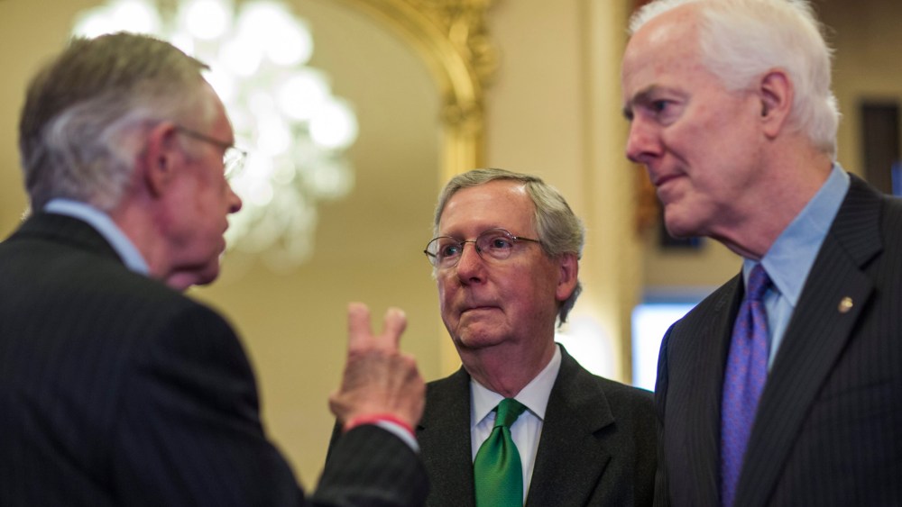 Republican Senate Minority Leader from Kentucky Mitch McConnell chats with Democratic Senate Majority Leader from Nevada Harry Reid in the US Capitol in Washington, D.C., February 12, 2014.