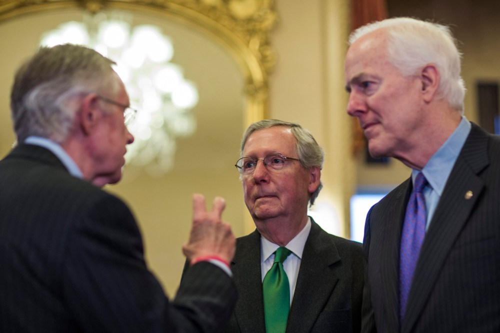 Republican Senate Minority Leader from Kentucky Mitch McConnell chats with Democratic Senate Majority Leader from Nevada Harry Reid in the US Capitol in Washington, D.C., February 12, 2014.