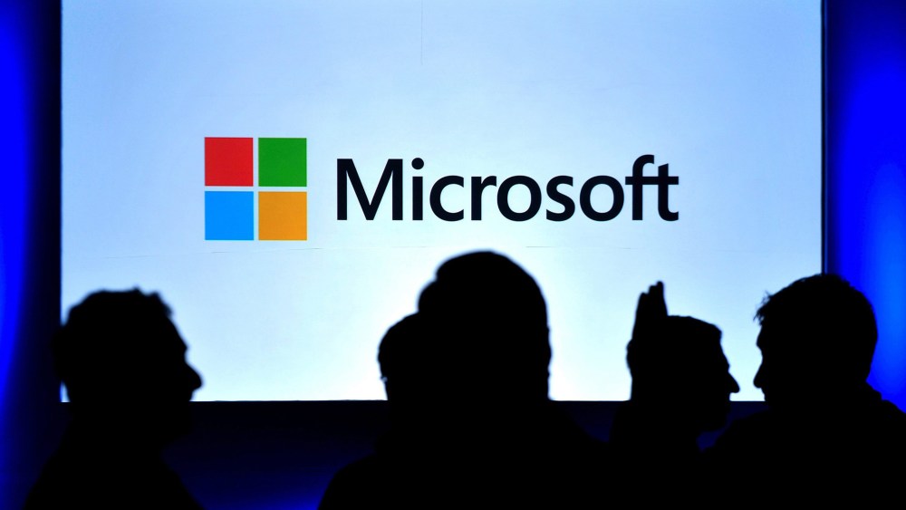 Visitors stand in front of a Windows 8 screen during its launch in Bangalore, India.