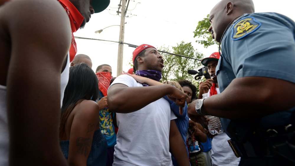 Captain Ron Johnson, of the Missouri State Highway Patrol (R) listens to protesters complaints about the death of Michael Brown across the street from a burned down Quik Trip gas station on West Florissant Avenue in Ferguson, Missouri, August 14, 2014.