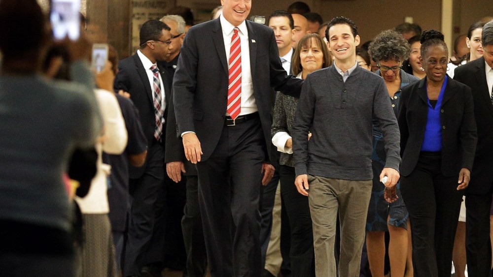 New York City Mayor Bill de Blasio (left) and his wife Chirlane McCray (right) flank Dr Craig Spencer (C) as Spencer leaves Bellevue Hospital after being declared free of the Ebola virus in New York, on Nov. 11, 2014.