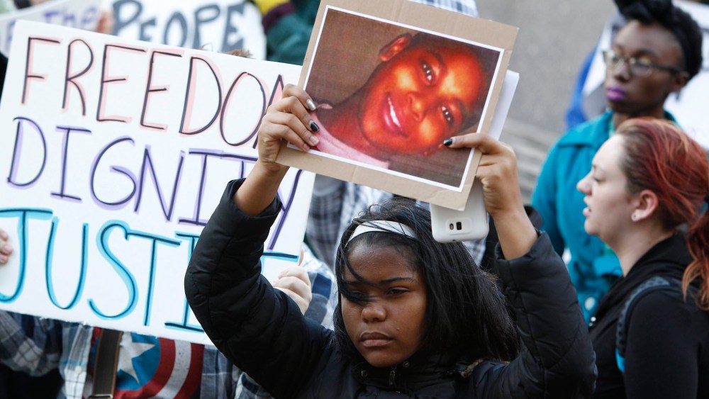 A protester holds a poster picturing shooting victim Tamir Rice, during a rally at Public Square in Cleveland, Ohio on Nov. 24, 2014.