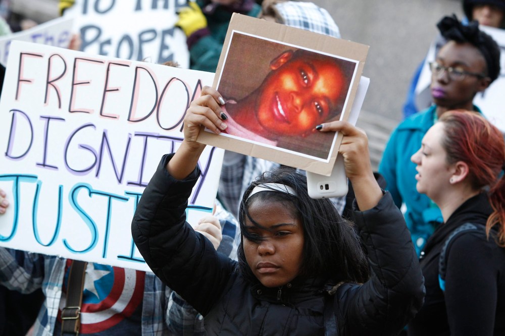 A protester holds a poster picturing shooting victim Tamir Rice, during a rally at Public Square in Cleveland, Ohio on Nov. 24, 2014.