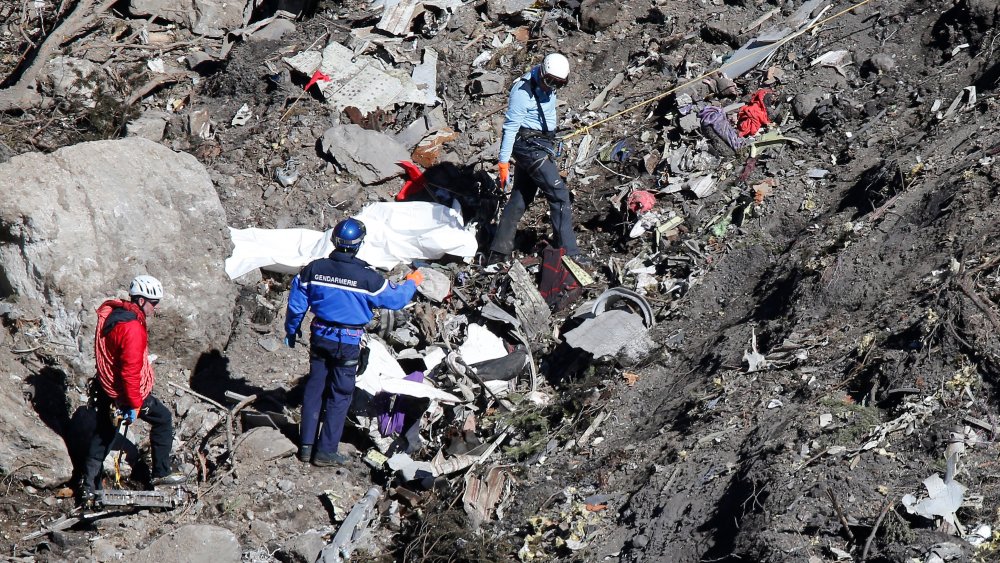 Search and rescue workers make their way through debris at the crash site of the Germanwings Airbus A320 that crashed in the French Alps, above the town of Seyne-les-Alpes, southeastern France on March 26, 2015.
