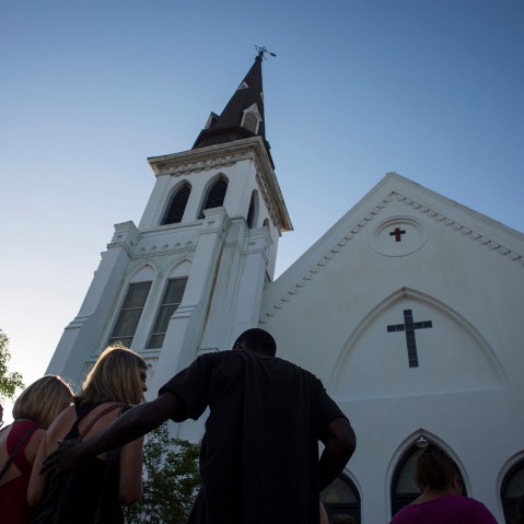 People comfort each other during a vigil at the memorial site outside of the Emanuel African Methodist Episcopal (AME) Church where nine people were murdered in Charleston, S.C., June 18, 2015. (Photo by John Taggart/EPA)