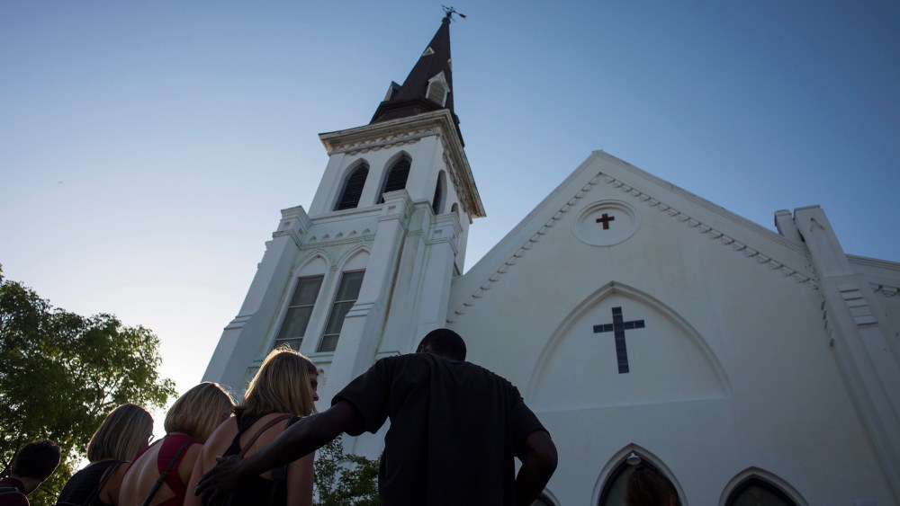 People comfort each other during a vigil at the memorial site outside of the Emanuel African Methodist Episcopal (AME) Church where nine people were murdered in Charleston, S.C., June 18, 2015. (Photo by John Taggart/EPA)