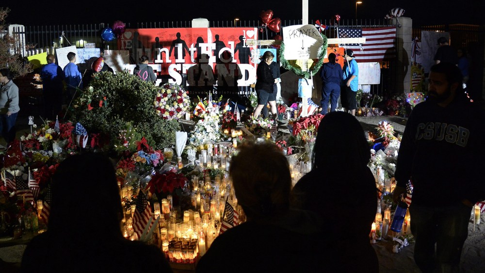 People gather around a makeshift memorial outside the Inland Regional Center where Syed Farook and wife Tashfeen Malik shot and killed 14 people, in San Bernardino, Calif., Dec. 7, 2015. (Photo by Mike Nelson/EPA)