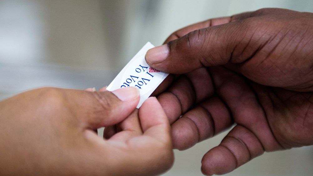 An 'I voted' sticker is handed out to a voter during the Maryland presidential primary election at Skyline Elementary School in Suitland, Md., April 26, 2016. (Photo by Shawn Thew/EPA)