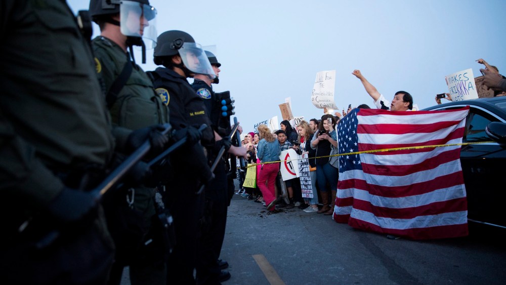 Protesters opposed to US Republican presidential candidate Donald Trump are separated from supporters by a line of riot police officers outside Trump's campaign rally in Costa Mesa, Calif., on April 28. 2016. (Photo by Eugene Garcia/EPA)
