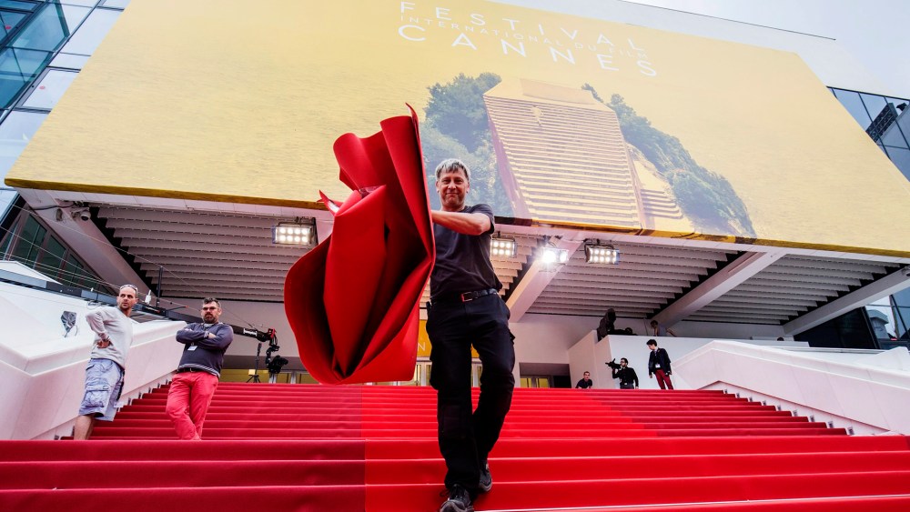 A worker installs the red carpet in front of the Festival Palace ahead of the 69th Cannes Film Festival, in Cannes, France, May 10, 2016. (Photo by Julien Warnand/EPA)