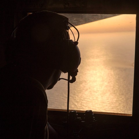A British Navy officer looks out the window of an Royal Air Force C-130 Hercules aircraft in the search and rescue operations for the missing EgyptAir flight MS804, May 19, 2016. (Photo by Helen Rimmer/British Ministry of Defense/EPA)