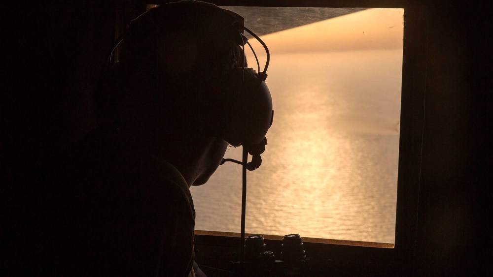 A British Navy officer looks out the window of an Royal Air Force C-130 Hercules aircraft in the search and rescue operations for the missing EgyptAir flight MS804, May 19, 2016. (Photo by Helen Rimmer/British Ministry of Defense/EPA)