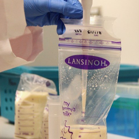 A researcher takes a sample of breast milk.