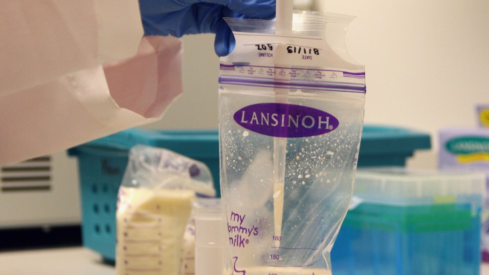 A researcher takes a sample of breast milk.