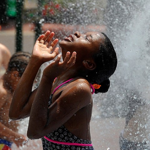 Children cool off during a hot summer day at a fountain in downtown Silver Spring, Maryland, on July 19, 2013.   (Photo by Jewel Samad/AFP/Getty Images)