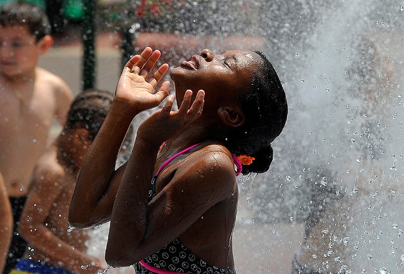 Children cool off during a hot summer day at a fountain in downtown Silver Spring, Maryland, on July 19, 2013.   (Photo by Jewel Samad/AFP/Getty Images)