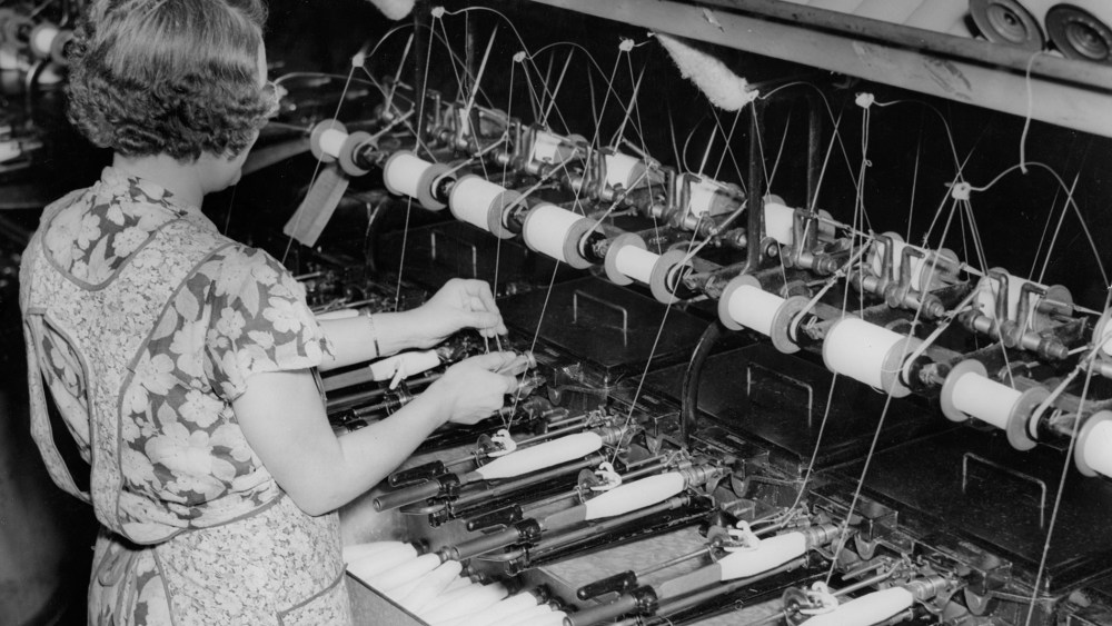 A female worker quilling at a textile mill, circa 1930.