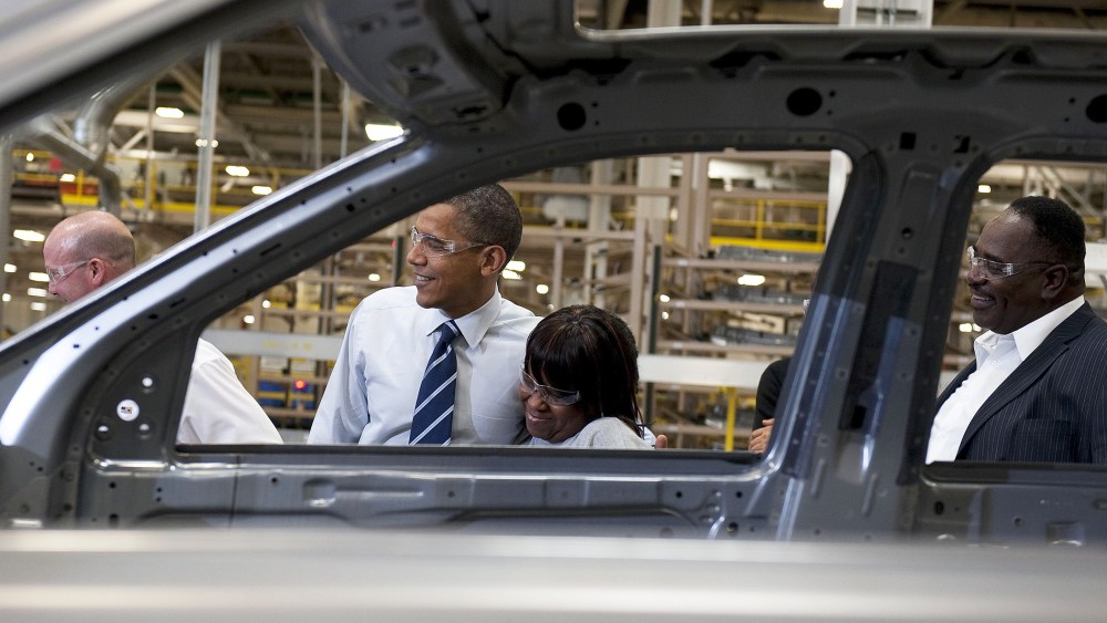 President Barack Obama (C) hugs an assembly line worker as he tours through the Chrysler Auto Plant in Detroit, Mich., July 30, 2010.