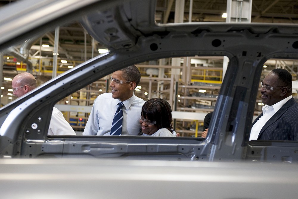President Barack Obama (C) hugs an assembly line worker as he tours through the Chrysler Auto Plant in Detroit, Mich., July 30, 2010.