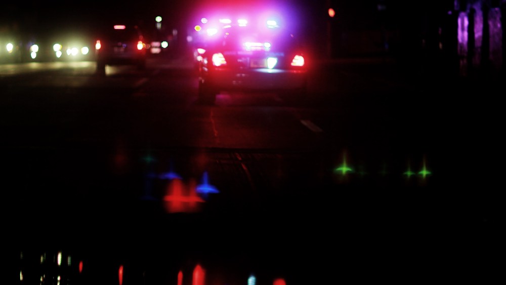A police car with lights ablaze responds to a call. (Photo by Joe Raedle/Getty)