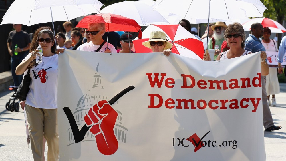 File Photo: Members of D.C. Vote and the League of Women Voters demonstrate in front of the White House to honor the 90th anniversary of the 19th Amendment guaranteeing women the right to vote August 26, 2010 in Washington, DC. The demonstrators also...