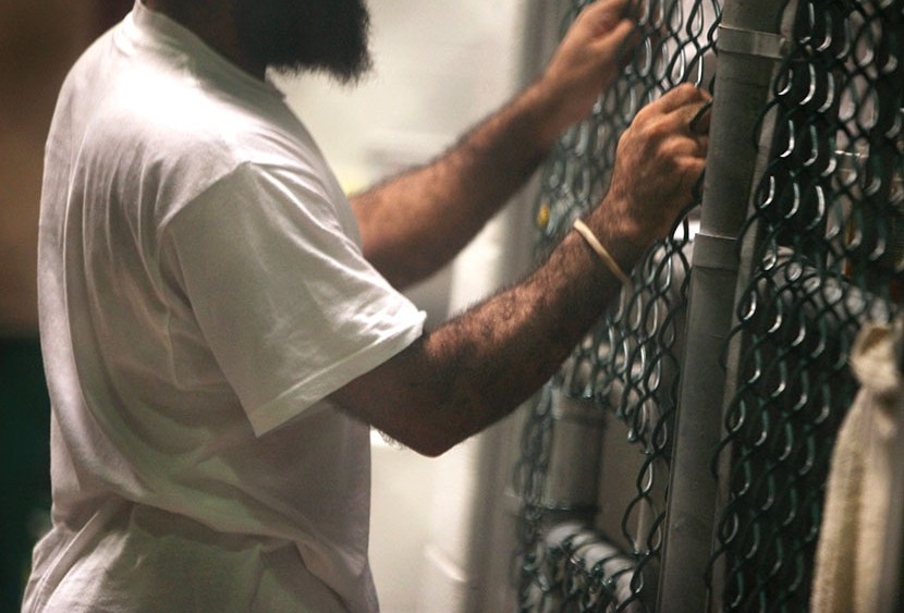 A detainee speaks through a fence at the U.S. detention center for "enemy combatants" on September 15, 2010 in Guantanamo Bay, Cuba.  (Photo by John Moore/Getty Images)