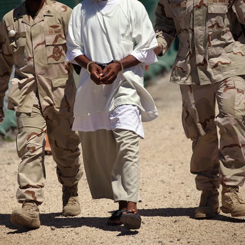 U.S. military guards move a detainee inside the American detention center for "enemy combatants" on September 16, 2010 in Guantanamo Bay, Cuba.  (Photo by John Moore/Getty Images)
