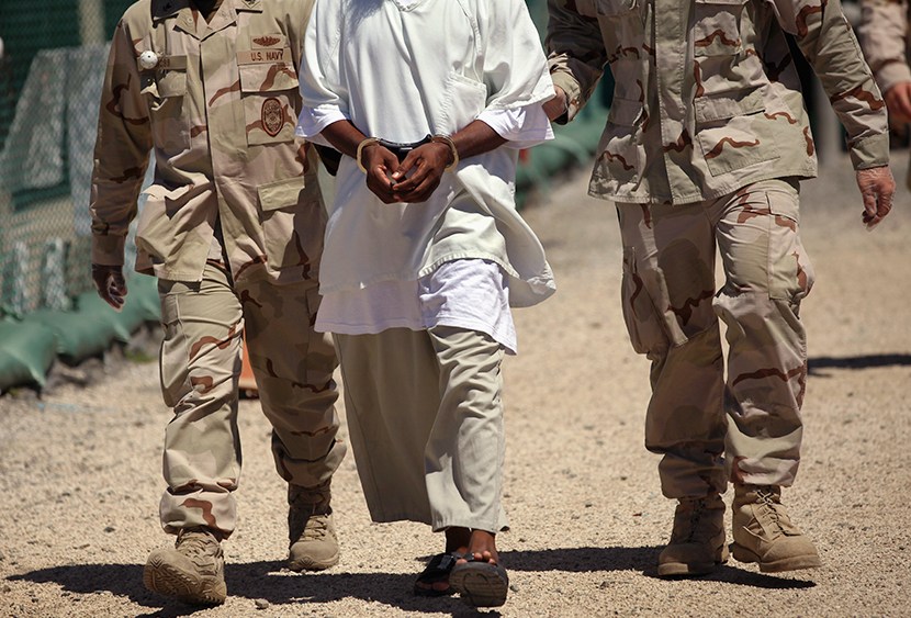 U.S. military guards move a detainee inside the American detention center for "enemy combatants" on September 16, 2010 in Guantanamo Bay, Cuba.  (Photo by John Moore/Getty Images)