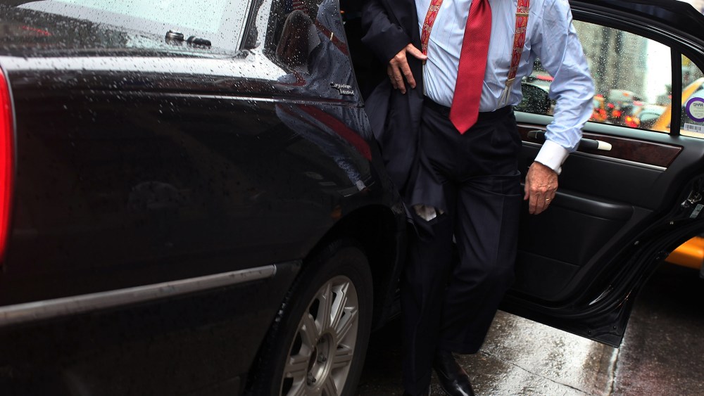 A business man gets out of a town car in New York City. (Photo by Spencer Platt/Getty)