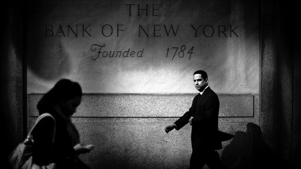 A businessman walks by the Bank of New York in Midtown Mahattan, home to many of the world's banks.