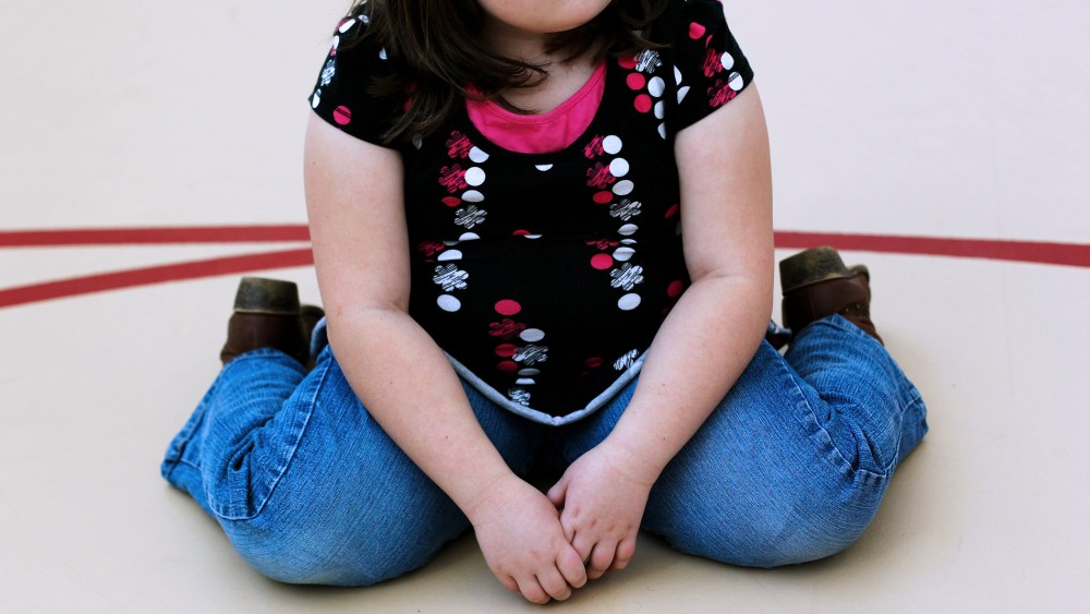 A child sits on the gym floor during the Shapedown program for overweight adolescents in Aurora, Colorado.