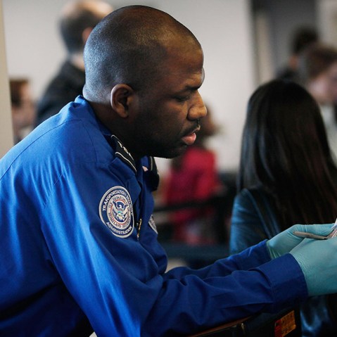 A Transportation Security Administration officer looks over the identification of a passenger during a security screening November 24, 2010 at LaGuardia airport in the Queens Borough of New York City.   (Photo by Chris Hondros/Getty Images)