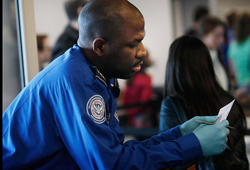 A Transportation Security Administration officer looks over the identification of a passenger during a security screening November 24, 2010 at LaGuardia airport in the Queens Borough of New York City.   (Photo by Chris Hondros/Getty Images)