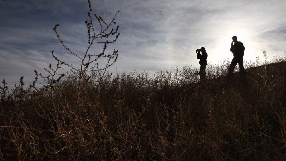 File Photo: U.S. Border Patrol agents Richard Funke and Colleen Agle look for illegal immigrants crossing the U.S.- Mexico border on December 7, 2010 near Nogales, Arizona. Although a new fence has been built along the majority of Arizona's border with...