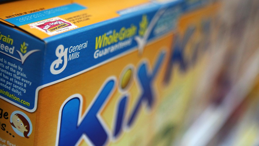 A box of General Mills cereal sits on the shelf.