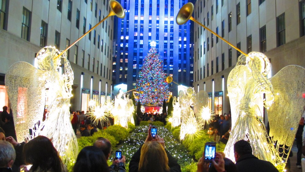 Tourists visit the Christmas tree at Rockefeller Center in New York City, December 5, 2013.