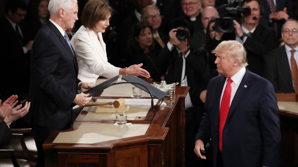 House Speaker Rep. Nancy Pelosi attempts to shake hands with President Donald Trump in the beginning of the State of the Union address as Vice President Mike Pence looks on in the chamber of the U.S. House of Representatives on February 04, 2020 in Washin