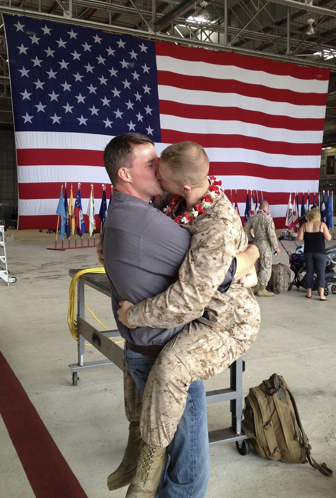 Sgt. Brandon Morgan, right, is embraced by his partner Dalan Wells in a helicopter hangar at a Marine base in Kaneohe Bay, Hawaii, upon returning from a six-month deployment to Afghanistan on February 22 of this year.