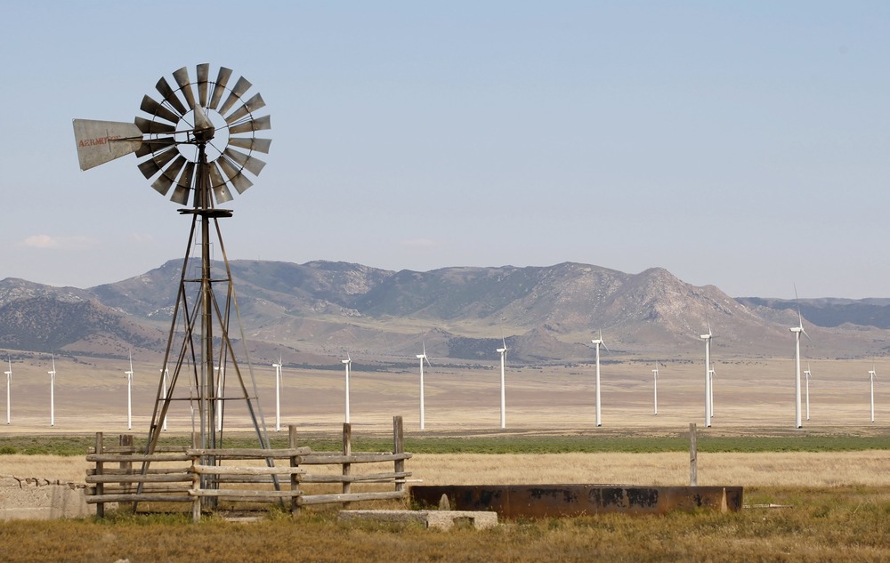An old style windmill is pictured with newer and larger wind turbines in the background, at a wind farm near Milford, Utah May 21, 2012.