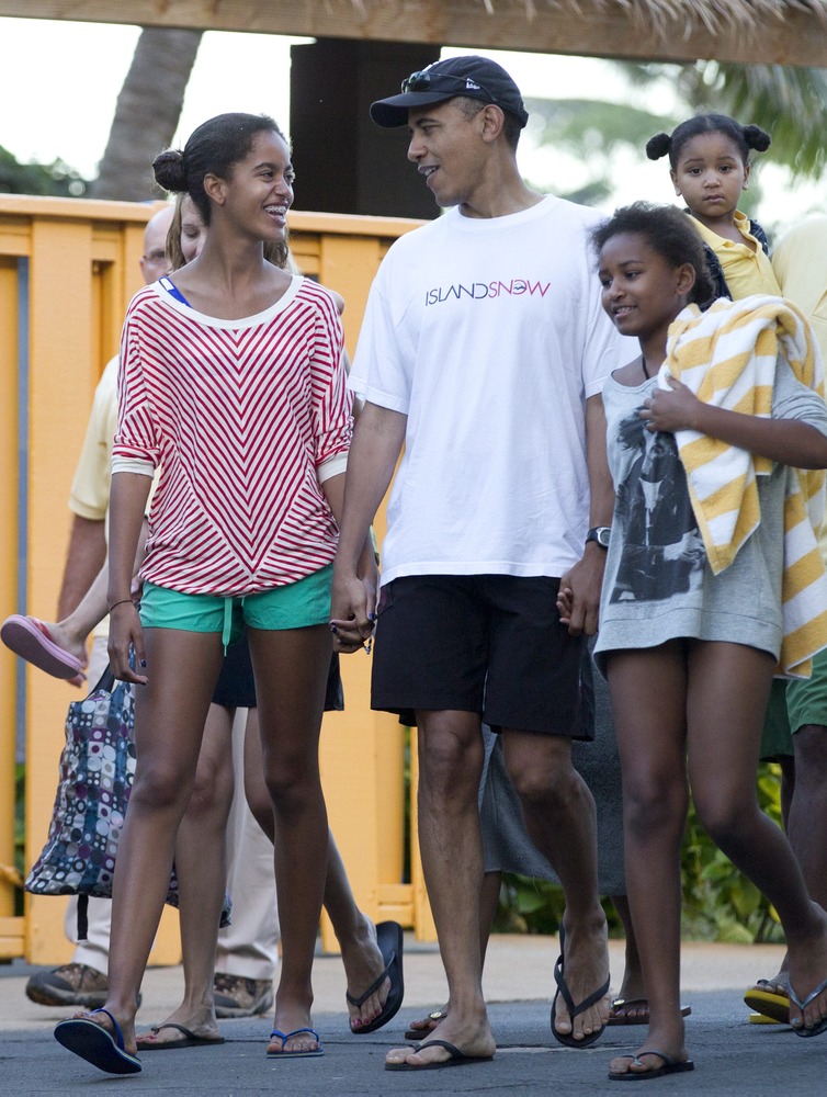President Barack Obama holding hands with his daughters Malia, left, and Sasha, right, leave Sea Life Park, a marine wildlife park, with family friends, Tuesday, Dec. 27, 2011, in Waimanalo, Hawaii.
