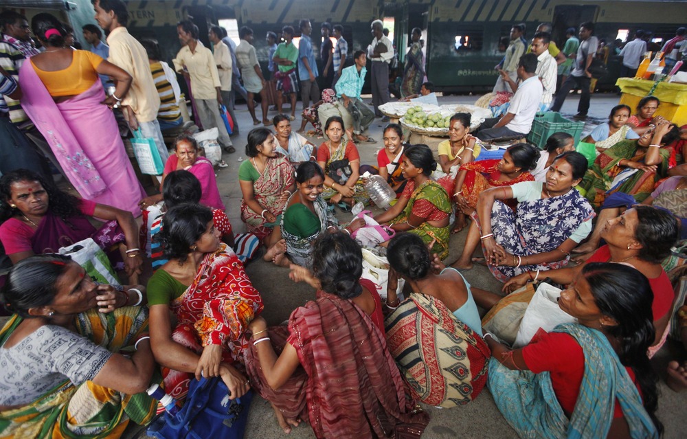 Passengers sit on a platform as they wait for the electricity to be restored at a railway station in Kolkata July 31.
