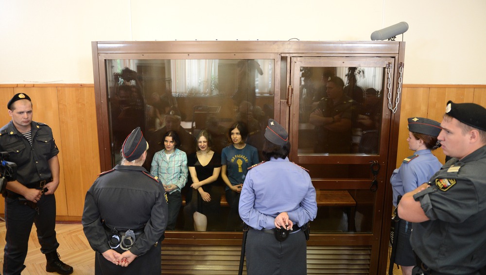 Members of the all-girl punk band "Pussy Riot" Yekaterina Samutsevich (L), Maria Alyokhina (C) and Nadezhda Tolokonnikova (R) sit in a glass-walled cage during a court hearing in Moscow on Agust 17, 2012.