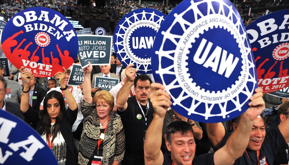 Supporters wave signs during President of the International Union, United Automobile, Aerospace and Agricultural Implement Workers of America (UAW)  Bob King 's address at the Time Warner Cable Arena in Charlotte, North Carolina, on September 5, 2012...
