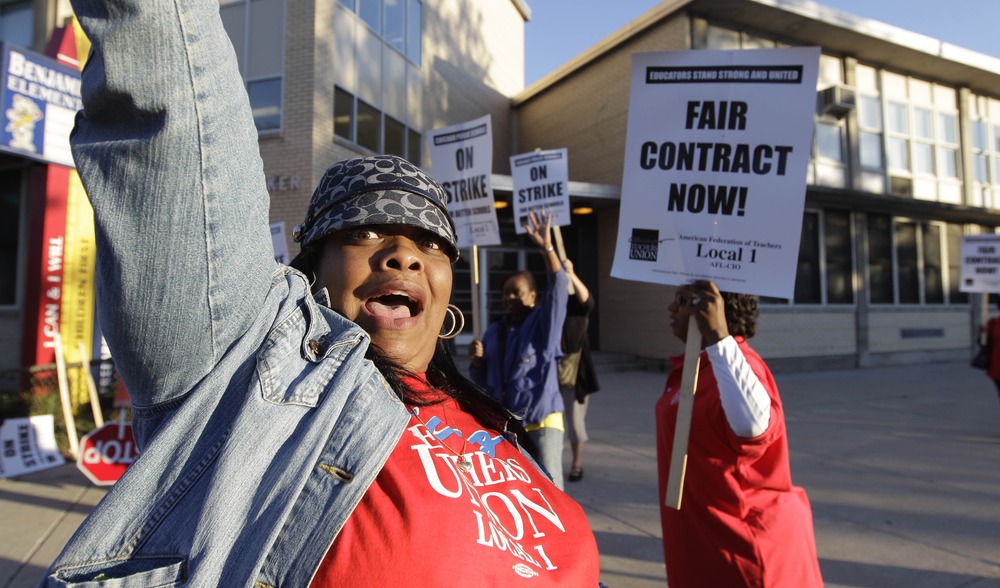 Chicago teachers walk a picket line outside Benjamin Banneker Elementary School in Chicago, Monday, Sept. 10, 2012, after they went on strike for the first time in 25 years.