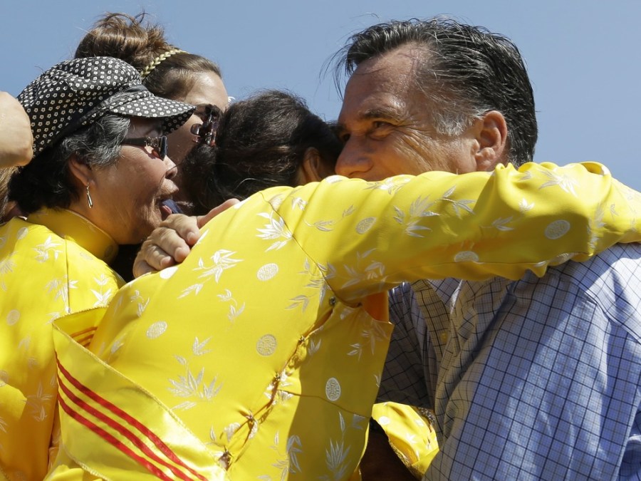 Mitt Romney embraces women wearing traditional Vietnamese 