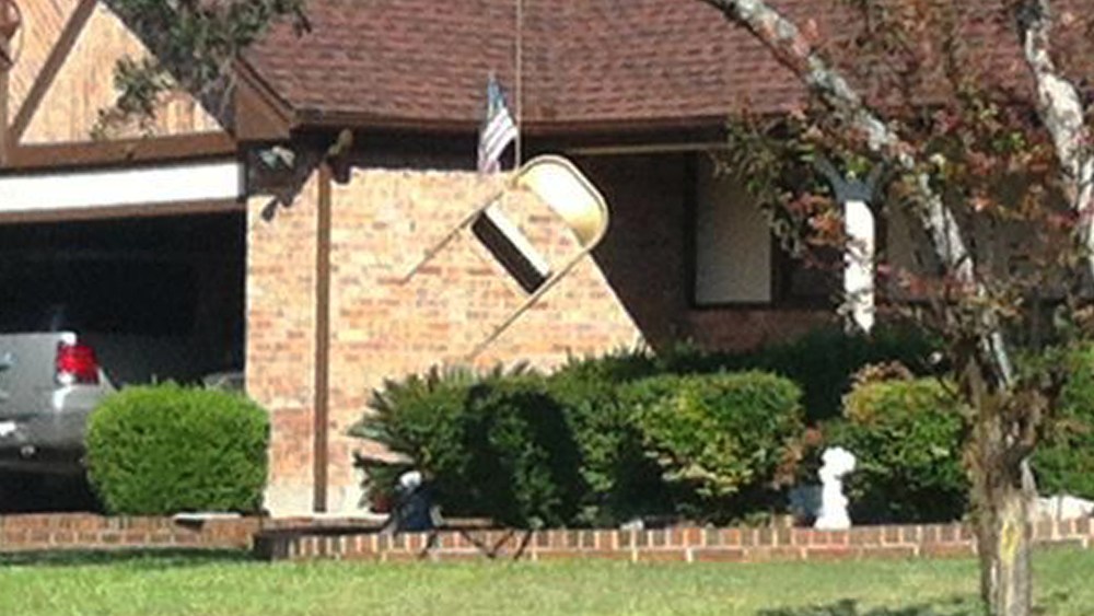 A folding chair and an American flag hang from a tree in front of a home in northwest Austin, Texas.
