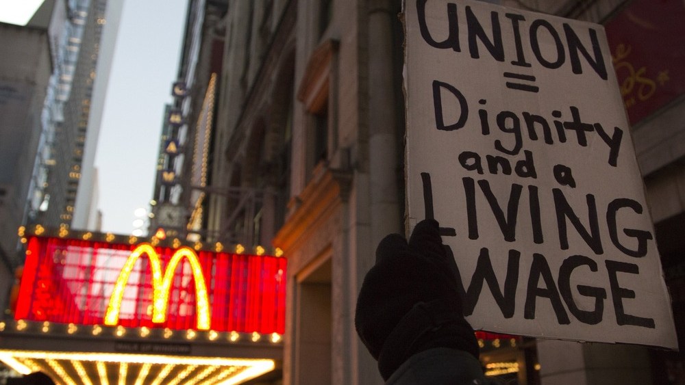 A protester holds up a sign at a demonstration outside McDonald's in Times Square in support of employees on strike at various fast-food chains in New York November 29, 2012. (REUTERS/Andrew Kelly)