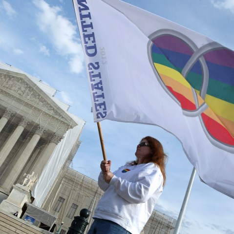Same-sex marriage proponent Kat McGuckin of Oaklyn, New Jersey, holds a gay marriage pride flag while standing in front of the Supreme Court November 30, 2012 in Washington, DC (Photo by Chip Somodevilla/Getty Images)